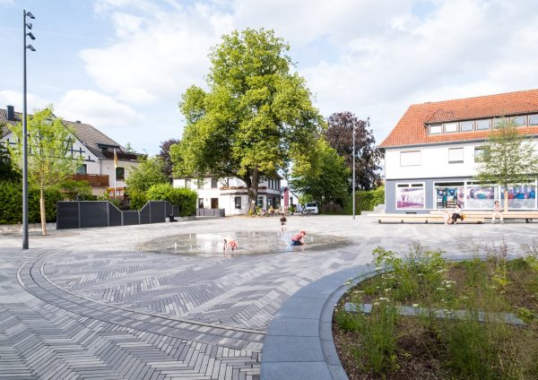 Blücherplatz in the town of Spenge, as it exists, is barely perceptible. The quality of stay and usability for pedestrians is severely restricted due to the dominance of motorised traffic. For the redesign it is necessary to fundamentally rethink the traffic situation and the open space. A uniform and qualitative covering of paving clinkers defines […]